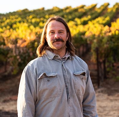 Portrait of Seth standing in front of Skinner vineyards