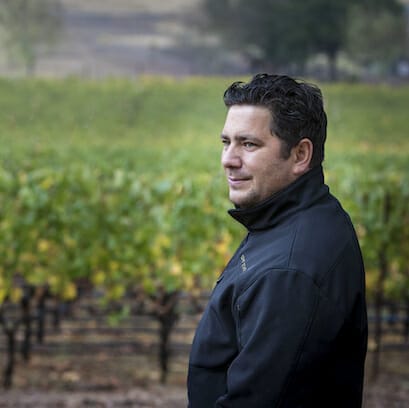 Julien Fayard standing in the vineyard.